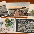 Five postcards with varied imagery on a wooden surface.